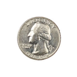 May include: A silver quarter coin with a profile of George Washington, inscribed with "LIBERTY" and "IN GOD WE TRUST." The coin also shows the years "1776-1976."