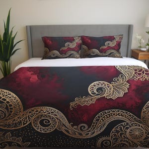 Peut inclure: Une housse de couette bordeaux et noire avec un motif de mandala doré. La housse de couette présente un fond aquarelle avec des motifs dorés complexes.
