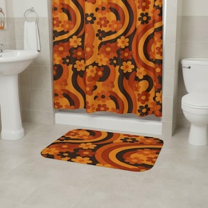 May include: A bathroom set with a retro design, including a shower curtain and bath mat. The pattern features flowers and curved lines in orange, brown, and black. The bathroom also includes a white sink and toilet.