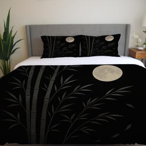 Könnte beinhalten: Schwarzes Bettwäsche-Set mit Bambus- und Vollmond-Design. Die Bambusstiele und Blätter sind grau auf schwarzem Hintergrund. Der Mond ist hellgelb. Das Set besteht aus Bettbezug und Kissenbezügen.
