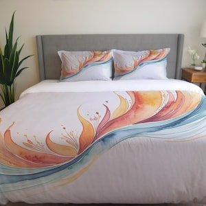 May include: A white duvet cover with a watercolor design of orange, yellow, and blue abstract flowers. The duvet cover is on a bed with two matching pillowcases.