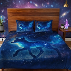 Puede incluir: Un juego de cama azul oscuro con un diseño de zorro celestial. El juego incluye una funda nórdica y dos fundas de almohada, todas adornadas con un cielo estrellado y una silueta de zorro brillante. La ropa de cama está colocada contra un cabecero de madera y una pared con temática de galaxia.