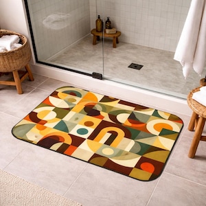 Pode incluir: Um tapete de banho retangular com um padrão geométrico em tons de laranja, amarelo, verde e castanho. O design apresenta formas abstratas, incluindo círculos, quadrados e arcos. O tapete tem uma borda preta e está colocado num chão ladrilhado.