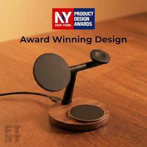 Op de afbeelding: Een houten en zwart oplaadstation met een ronde basis en drie oplaadpads. Het ontwerp omvat een rond pad, een horloge-oplaadstandaard en een groter rond pad. De tekst "Award Winning Design" wordt weergegeven.
