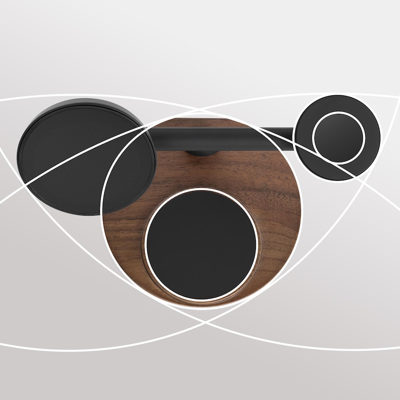 May include: A modern, minimalist bathroom accessory featuring a dark wood base with a black metal bar and circular accents. The design includes three black circular elements and a sleek, dark bar, creating a contemporary aesthetic.