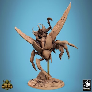 May include: A detailed figurine of a warrior riding a large insect-like creature with large wings. The warrior is holding a weapon. The base of the figurine has the text "PIT OF PESTILENCE VOLUME II". The background is a solid blue.