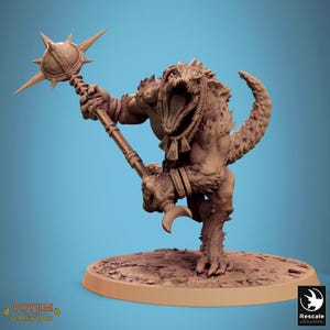 May include: A detailed figurine of a reptilian humanoid creature with an open mouth, holding a spiked mace. The figure is tan with textured skin and stands on a circular base. The image has a blue background.
