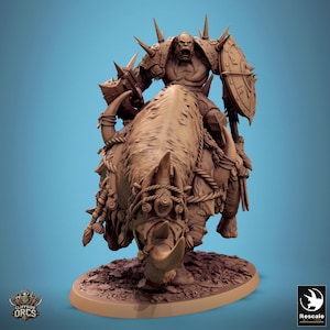 May include: A detailed figurine of an orc warrior riding a large, horned beast. The orc is armored and carries a shield. The beast is adorned with rope and decorative elements. The base of the figurine is oval-shaped, and the overall color is a muted brown.