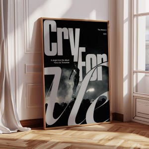 May include: A framed poster with a black background and large white text that reads "Cry for Me". The poster features an image of a performer on stage and the text "The Weeknd 2025". The poster is in a gold frame.