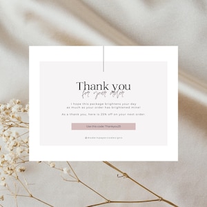 May include: A thank you card with the text "Thank you for your order" in elegant script. The card includes a message offering a discount on the next order with the code "Thankyou25". The background is a soft, neutral color.
