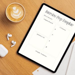 Peut inclure: Vue aérienne d'un bureau en bois avec une tablette affichant un "Modèle de préparation à l'entretien". Une tasse de café, des écouteurs sans fil blancs et un étui de chargement sont également sur le bureau. Le modèle comprend des sections pour la recherche d'entreprise, les questions et les réponses STAR.