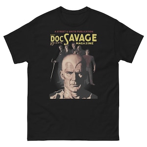 May include: A black t-shirt with a vintage comic book cover design featuring Doc Savage, a pulp fiction hero. The cover features a close-up of Doc Savage's face and the text "Doc Savage Magazine 10 Cents".