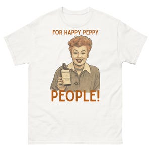 May include: White t-shirt featuring a vintage illustration of a woman winking and holding a bottle. The text on the shirt reads "FOR HAPPY PEPPY PEOPLE!" in brown letters. The woman is wearing a collared shirt and a pearl necklace.