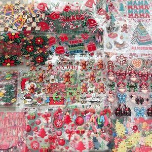 May include: A collection of Christmas-themed stickers featuring various designs. The stickers include gingerbread men, Santa faces, bows, Christmas trees, and holiday phrases. Colors include red, green, white, and gold. The stickers are on clear sheets.
