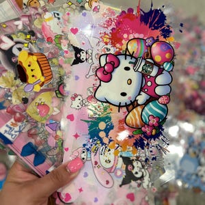 May include: A set of colorful, transparent stickers featuring Hello Kitty and other cartoon characters. The stickers are decorated with hearts, stars, and other cute designs. The stickers are perfect for adding a touch of whimsy to your planner, journal, or laptop.