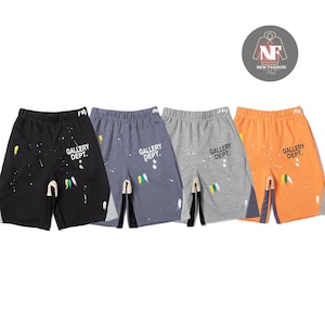 Könnte beinhalten: Vier Shorts in Schwarz, Blau, Grau und Orange. Jedes Paar hat weiße Farbspritzer und den Text "GALLERY DEPT." auf dem Bein aufgedruckt. Die Shorts haben einen Kordelzugbund und einen Schlitz.