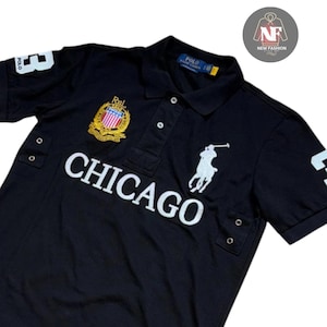 May include: Black polo shirt with white "CHICAGO" text, a crest, and the number "3". Features the Polo Ralph Lauren logo. The shirt has a classic collar and button placket. The shirt is a short-sleeved style.