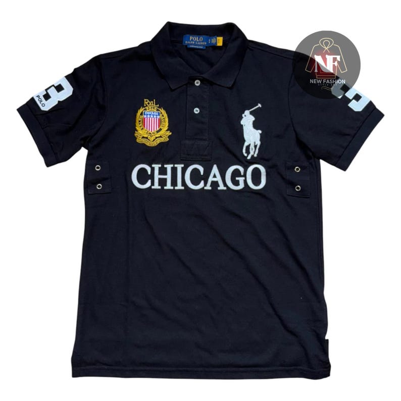 May include: Black polo shirt with white "CHICAGO" text across the chest. Features a white polo player logo, a crest, and the number "3" on the sleeve. The shirt has a button-down collar.