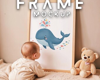 Könnte beinhalten: Ein gerahmter Kunstdruck mit einer Illustration eines blauen Wals und farbenfrohen Akzenten. Der Rahmen ist hellbraun. Ein Baby betrachtet das Kunstwerk, und ein Teddybär sitzt neben dem Rahmen. Der Text "FRAME MOCKUP" steht oben.