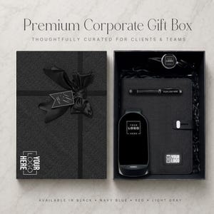 May include: A black gift box set featuring a textured lid with a black ribbon bow and the text "YOUR LOGO HERE". Inside, a black notebook, a pen, and a wireless charger are arranged on black paper filler, each marked with "YOUR LOGO HERE".