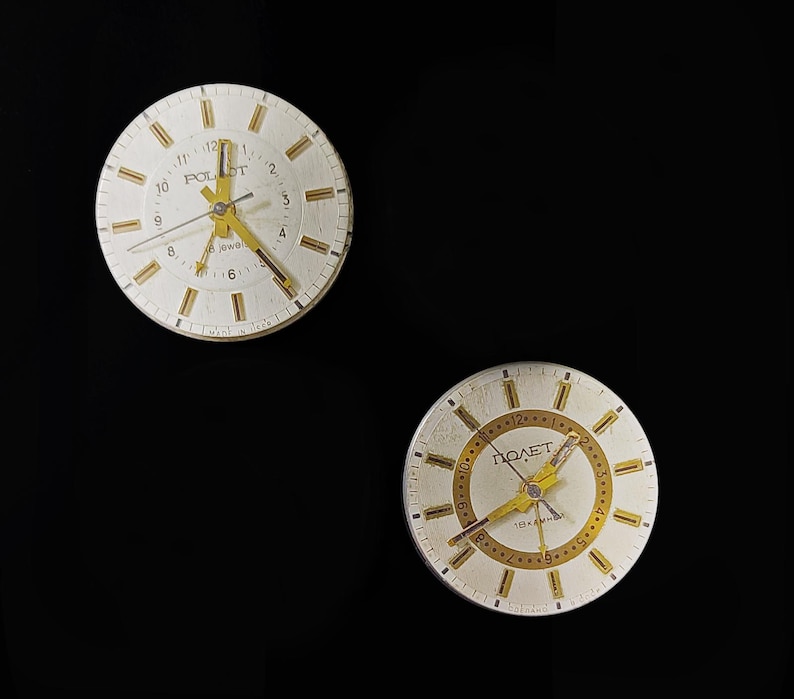 May include: Two vintage Poljot wristwatches with white faces, gold hands, and hour markers. The watch faces display the brand name and the word "Jewels". The watches are set against a black background.
