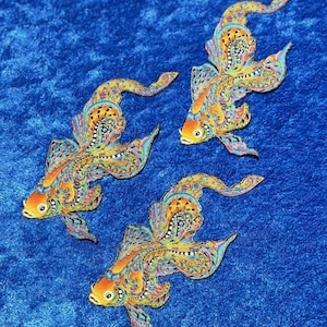 May include: Three decorative fish with orange heads and patterned bodies in shades of yellow, blue, and orange. The fish are set against a blue background, creating a vibrant and eye-catching design. The fish have detailed patterns.