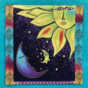 May include: Square fabric with a celestial design featuring a smiling sun, crescent moons, and stars against a dark blue background. The sun is yellow and green, and the moons are blue and yellow. The border has geometric patterns in red, gold, and turquoise.