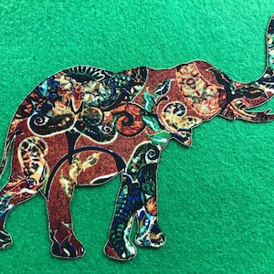 May include: A colorful elephant silhouette with a paisley pattern on a green background.
