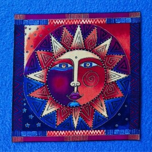 May include: A colorful sun with a stylized face and a geometric pattern. The sun is surrounded by a blue and red border with a geometric pattern.