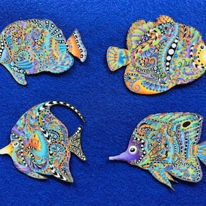 May include: Four colorful, intricately patterned fish ornaments. Each fish is a different design with a mix of blue, green, orange, yellow, and purple colors.