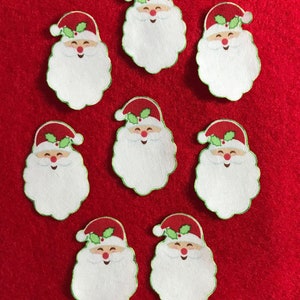 May include: Eight Santa Claus face cutouts with red hats, white beards, and smiling faces. Each cutout has a green border and holly accents on the hat. The cutouts are arranged on a red background, perfect for holiday crafts.