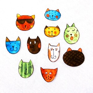 Peut inclure: Une collection de dix visages de chats peints à la main avec différentes expressions. Les chats sont peints dans des couleurs vives, notamment le bleu, le vert, l'orange, le jaune et le brun. Chaque chat a des caractéristiques uniques, comme des lunettes de soleil, un motif rayé ou une fleur.