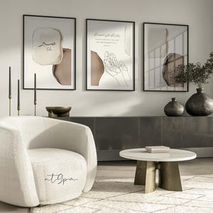 May include: Three framed prints with abstract brown and beige watercolor designs. The center print features a line drawing of hands in prayer with Arabic text. The text reads "And your Lord said, "Call upon Me, and I will respond to you."