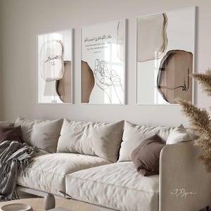 May include: Three framed prints with abstract brown watercolor shapes and Arabic calligraphy. The center print features the text "And your Lord said, "Call upon Me, and I will answer you." The left print features the word "Subh" in Arabic calligraphy. The right print features the word "Allah" in Arabic calligraphy.