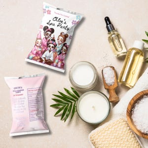 May include: Two pink and white bags of spa-themed party favors with a cartoon illustration of girls wearing spa robes and face masks. The bags are labeled "Chloe's Spa Party".