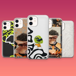 May include: A collection of five iPhone cases with various designs. The cases feature images of a person, abstract patterns, and a cartoon character with a racing helmet. The cases are in a row against a gradient pink background.