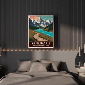 Pode incluir: Um pôster de estilo vintage com uma vista panorâmica do Parque Provincial Kananaskis em Alberta, Canadá. O pôster apresenta uma cordilheira, um caminho sinuoso e um lago turquesa. O texto "Kananaskis Provincial Park" está impresso em marrom na parte inferior do pôster.