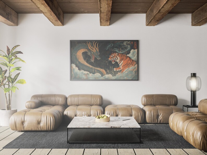 K&ouml;nnte beinhalten: Ein braunes Ledersofa in L-Form mit einem schwarzen Couchtisch davor. Ein gerahmtes Bild eines Tigers und eines Drachen in einer Wolkenlandschaft h&auml;ngt an der Wand hinter dem Sofa. Eine Lampe mit einem klaren Glasschirm steht auf einem schwarzen Beistelltisch rechts neben dem Sofa.