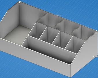 May include: A gray desk organizer with multiple compartments of varying sizes. The organizer is rectangular with angled sides and is set against a blue grid background. The dimensions are approximately 250 mm.