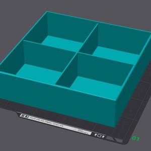 Peut inclure: Un conteneur rectangulaire turquoise avec quatre compartiments internes. L'objet est affiché sur une surface gris foncé, avec un petit carré blanc et gris et une flèche bleue dans le coin. Le texte en bas indique "#3 PLA PETG FRIS/TPU/PC".