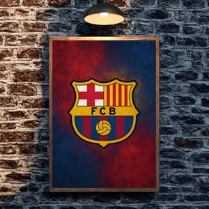 May include: Framed poster featuring the FC Barcelona crest. The crest is a shield shape with a cross, stripes, and a soccer ball. The background is a blend of red and blue hues, creating a dynamic visual effect. The frame is a dark wood.