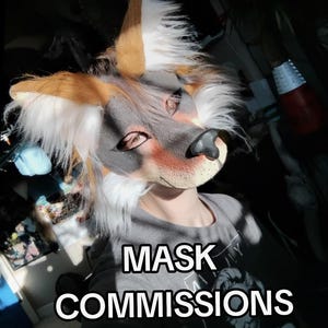 May include: A close-up of a furry fox mask with brown, white, and gray fur. The mask has a black nose and is worn by a person wearing a gray t-shirt. The text "MASK COMMISSIONS" is displayed in white letters.