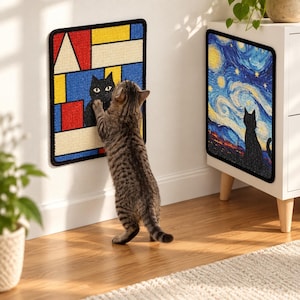 Puede incluir: Dos rascadores rectangulares para gatos con bordes negros. Uno presenta un patrón geométrico de bloques rojos, amarillos y azules con la silueta de un gato negro. El otro muestra una escena de cielo estrellado con la silueta de un gato.