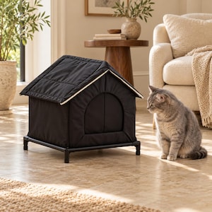 May include: A black, house-shaped pet bed with a peaked roof and a rounded entrance, supported by a black metal frame with four legs. The structure features quilted fabric panels and a light-colored trim along the roofline, providing a raised sleeping area.