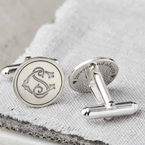 May include: Silver cufflinks with a monogrammed initial on one side and the words "forever and always" on the other side.