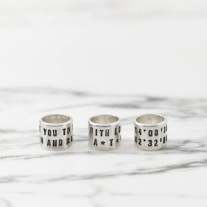 Puede incluir: Tres anillos de plata con texto grabado. El primer anillo dice "If you to in and ba", el segundo anillo dice "With Lo A*T*C", y el tercer anillo dice "54*08*13 02*32*00".