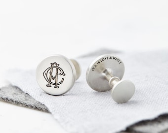 Puede incluir: Un par de gemelos de plata con un diseño de monograma en un gemelo y la inscripción "19.6.16 LOVE ALWAYS X" en el otro gemelo.