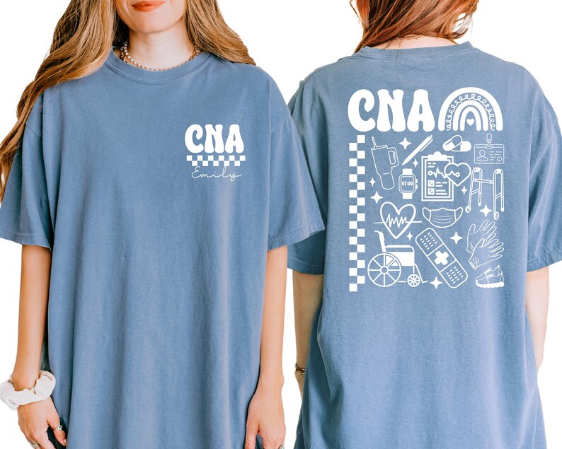 K&ouml;nnte beinhalten: Hellblaues T-Shirt mit den wei&szlig;en Buchstaben "CNA" &uuml;ber einem Schachbrettmuster. Auf der R&uuml;ckseite des Shirts befindet sich eine wei&szlig;e Grafik mit einem Regenbogen, medizinischen Symbolen und den Buchstaben "CNA".