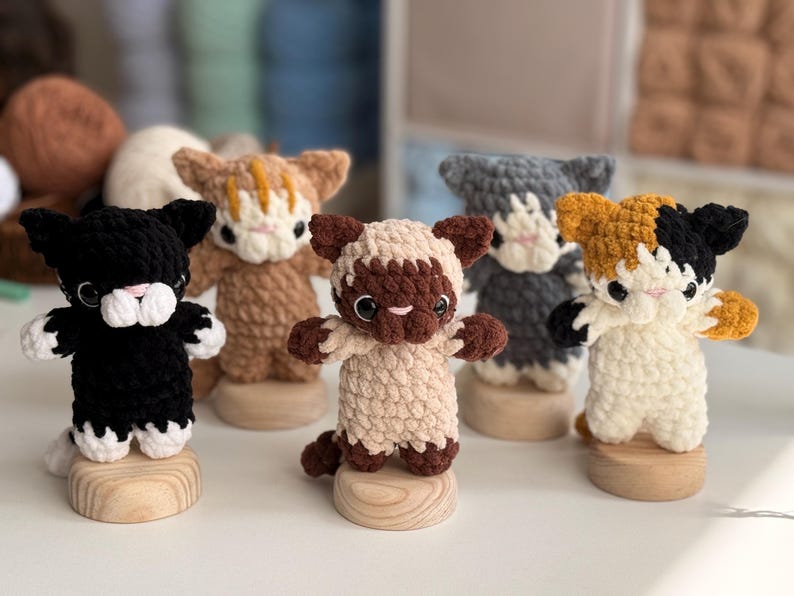 Puede incluir: Colecci&oacute;n de seis figuras de gato de ganchillo hechas a mano en varios colores, incluyendo negro, marr&oacute;n, gris y carey. Cada gato est&aacute; montado sobre una peque&ntilde;a base de madera, mostrando sus detalles y adorables poses.