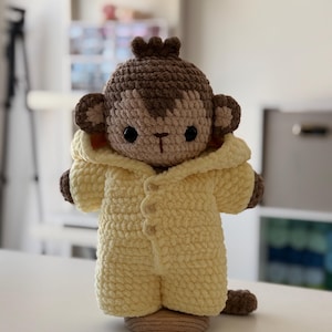 May include: A white ceramic mug with a black handle and the text "But First, Coffee" in a black, handwritten-style font. The mug is on a white surface.